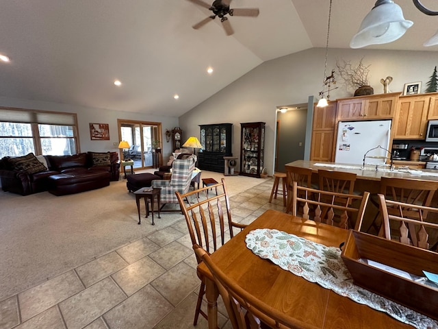 tiled dining room with high vaulted ceiling, ceiling fan, and sink