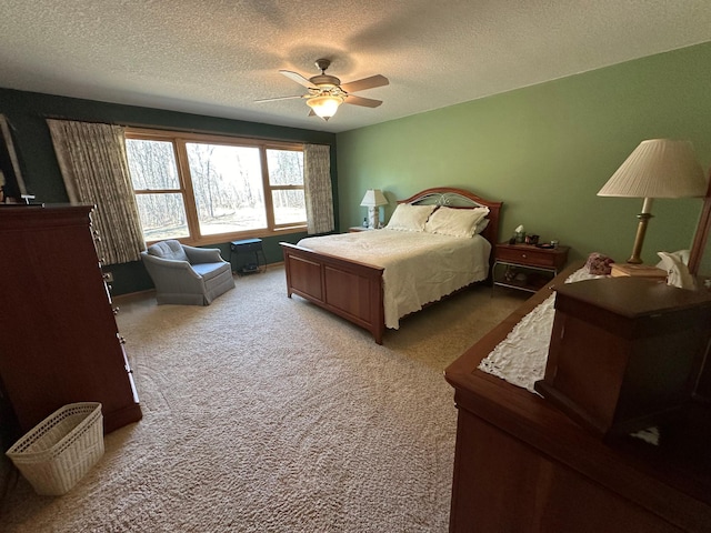 bedroom featuring a textured ceiling, ceiling fan, and light carpet