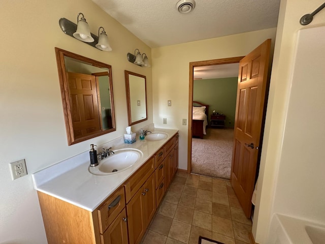 bathroom featuring double vanity, tile flooring, and a textured ceiling