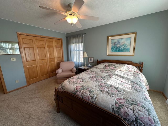 carpeted bedroom with ceiling fan, a closet, and a textured ceiling