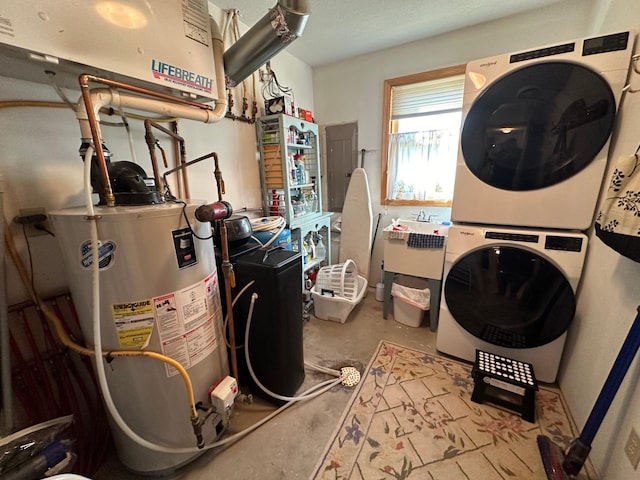 utility room with water heater and stacked washer / drying machine