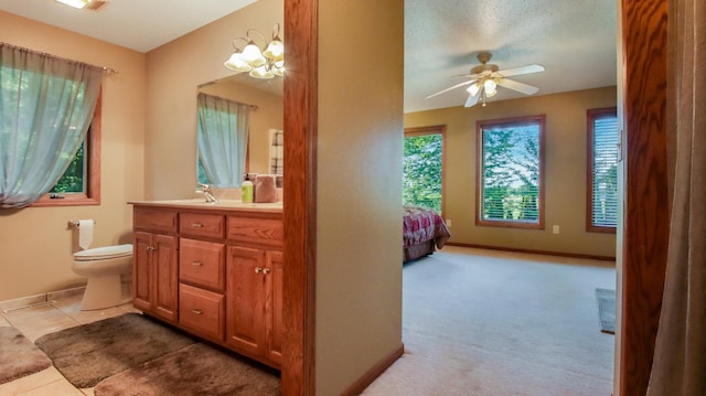 bathroom featuring toilet, tile patterned flooring, a textured ceiling, ceiling fan with notable chandelier, and vanity