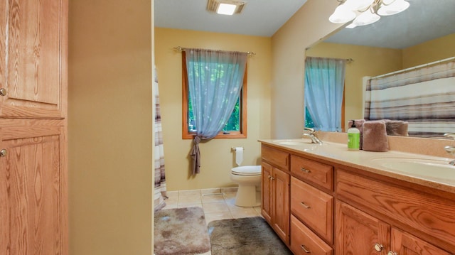 bathroom with tile patterned floors, vanity, toilet, and a notable chandelier