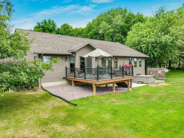 back of property featuring a deck, a hot tub, and a lawn