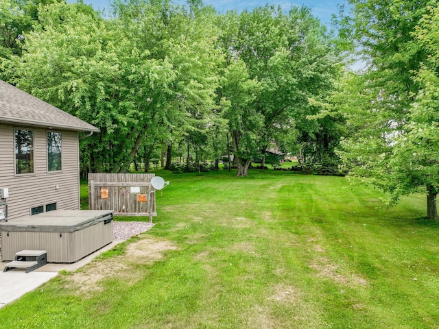 view of yard with a storage shed and a hot tub