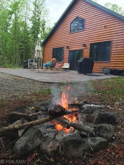 back of house with a patio area and log veneer siding
