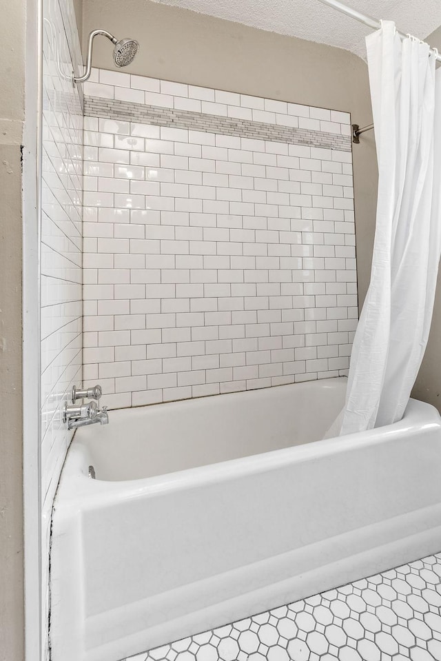 bathroom with a textured ceiling, tile patterned flooring, and shower / bath combo with shower curtain