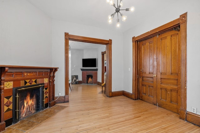 corridor with light hardwood / wood-style floors and a notable chandelier