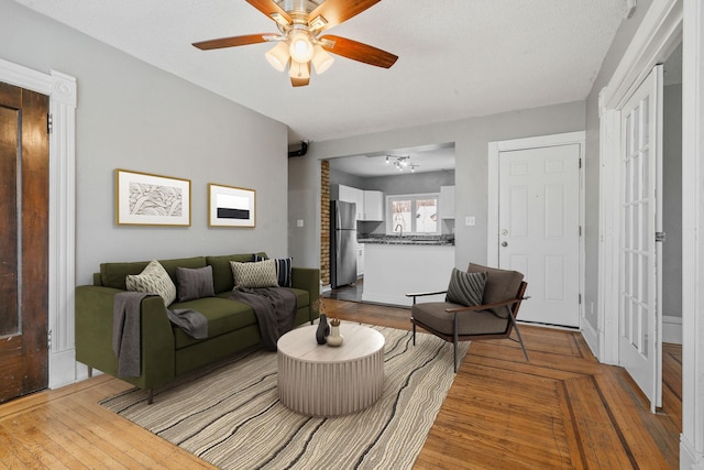 living room featuring light hardwood / wood-style floors, sink, ceiling fan, and french doors