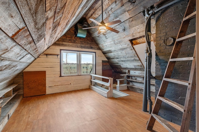 bonus room featuring ceiling fan, vaulted ceiling, wood walls, and light hardwood / wood-style floors