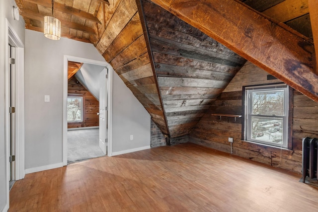 additional living space featuring lofted ceiling, hardwood / wood-style flooring, wooden walls, and wooden ceiling