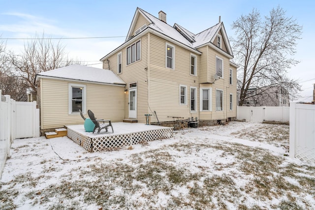 snow covered property with a deck and cooling unit