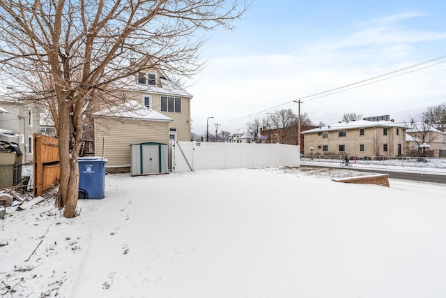 snowy yard with a storage shed