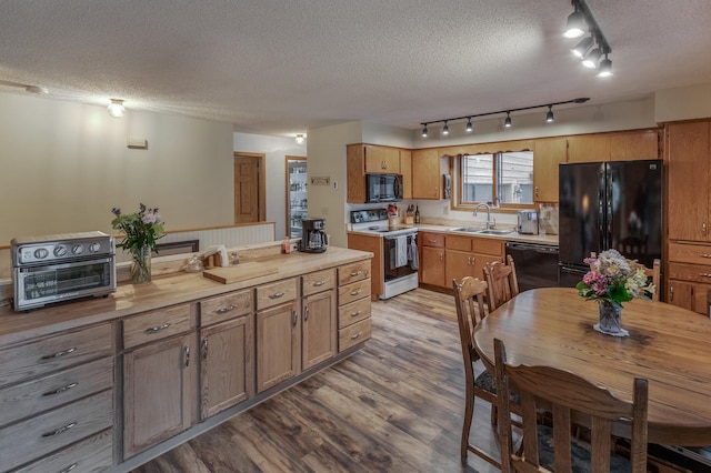 kitchen featuring black appliances, a textured ceiling, sink, and light hardwood / wood-style flooring