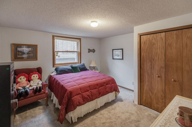 carpeted bedroom with a textured ceiling and a closet