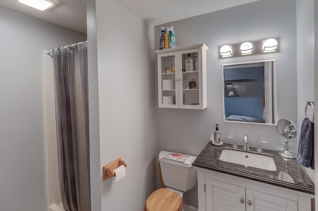 bathroom featuring vanity, toilet, a textured ceiling, and walk in shower