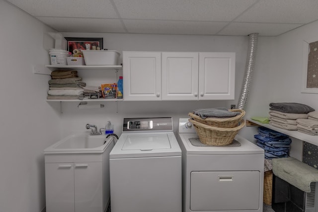 washroom with cabinets, sink, and washer and dryer