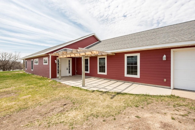 back of house featuring a garage, a lawn, a patio area, and a pergola