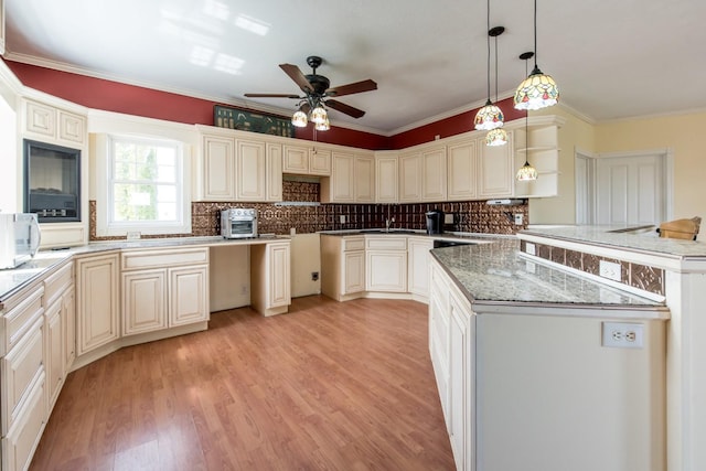 kitchen featuring crown molding, backsplash, cream cabinets, decorative light fixtures, and light wood-type flooring