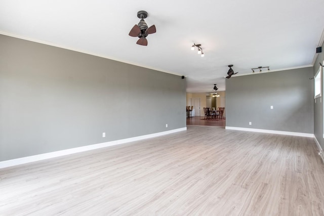 empty room with ornamental molding, track lighting, ceiling fan, and light hardwood / wood-style flooring