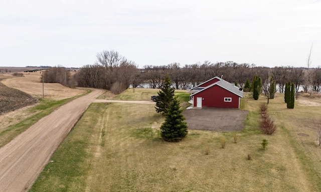 view of yard featuring a garage, a water view, and a rural view