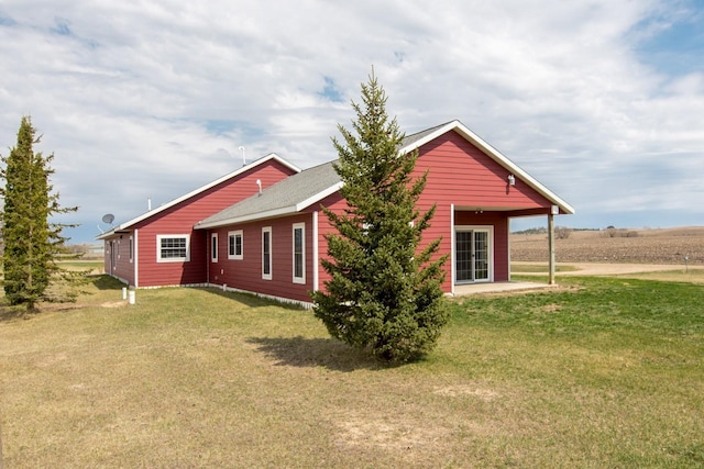 view of side of property with a yard and a patio area