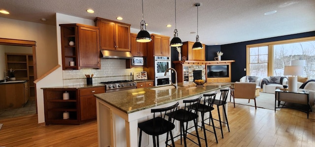 kitchen featuring sink, appliances with stainless steel finishes, hanging light fixtures, and a kitchen breakfast bar