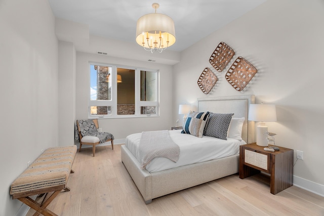 1 Hill Farm Rd Unit 107, North Oaks, MN 55127 - bedroom featuring baseboards, wood finished floors, a notable chandelier, and visible vents