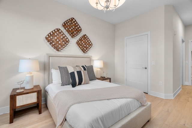 1 Hill Farm Rd Unit 107, North Oaks, MN 55127 - bedroom with baseboards, wood finished floors, and a chandelier