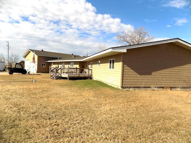 exterior space with a wooden deck and a lawn