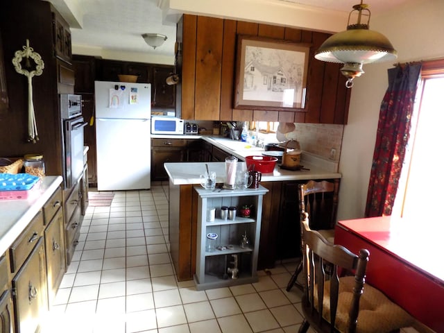 kitchen with backsplash, white appliances, pendant lighting, and light tile floors