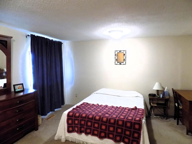 bedroom featuring light colored carpet and a textured ceiling