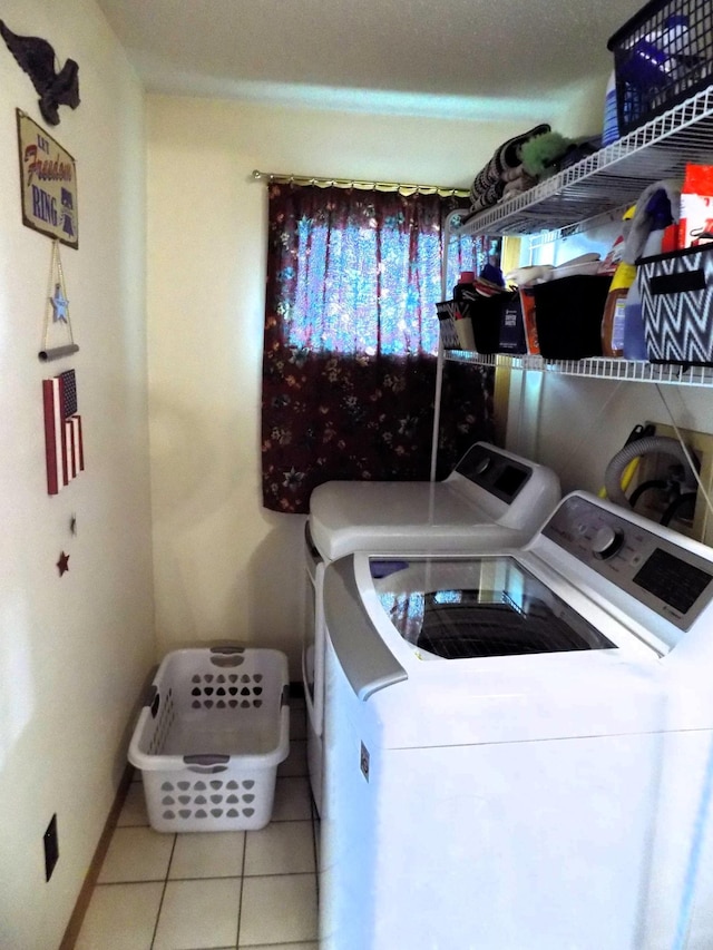 laundry room with independent washer and dryer and light tile floors