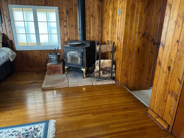 interior details with a wood stove, wood walls, and wood finished floors