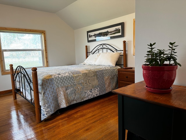 bedroom with lofted ceiling and wood finished floors