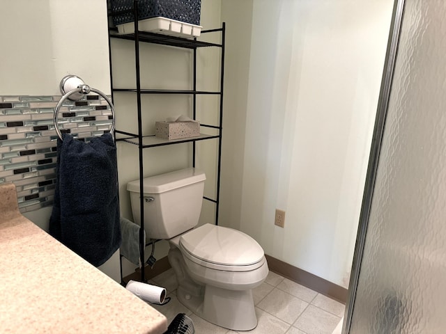 bathroom featuring tile patterned flooring, toilet, and baseboards