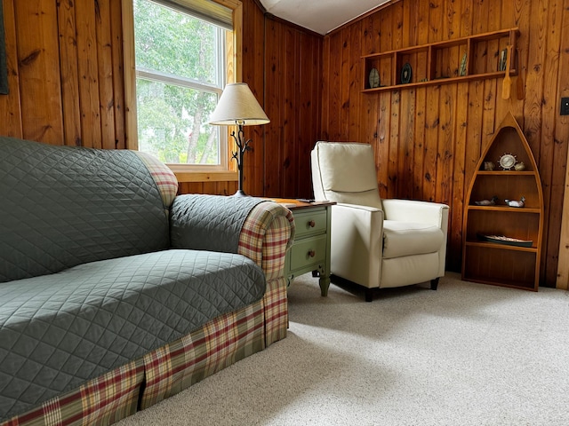 living area with wooden walls, vaulted ceiling, and carpet flooring