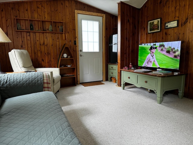 carpeted bedroom featuring vaulted ceiling, wood walls, and fridge