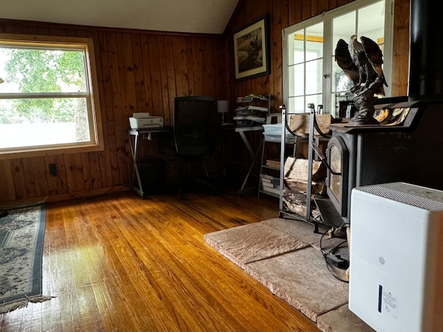 office featuring vaulted ceiling, wooden walls, and hardwood / wood-style floors