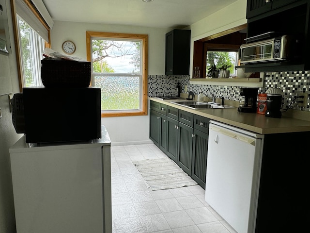 kitchen featuring a sink, decorative backsplash, dishwasher, and light countertops