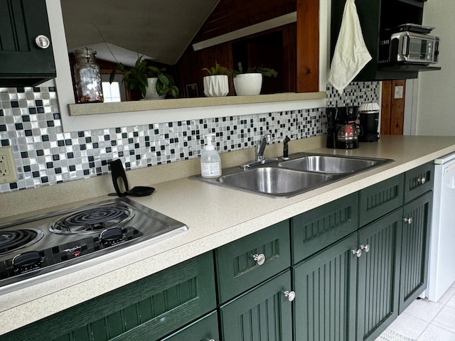 kitchen featuring stainless steel stovetop, green cabinets, and a sink