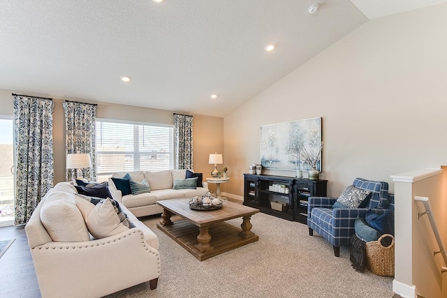 living room with a textured ceiling, vaulted ceiling, and light wood-type flooring