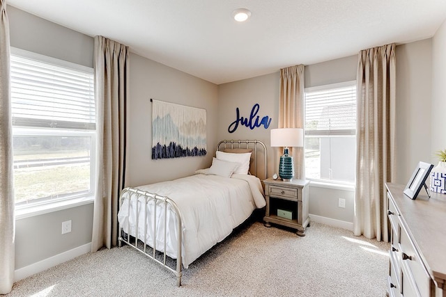 bedroom with multiple windows and light colored carpet