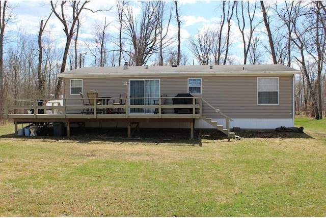 rear view of house featuring a lawn and a deck