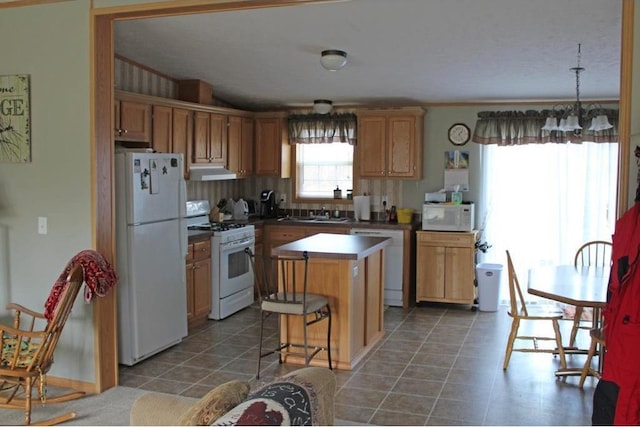 kitchen featuring dark tile patterned floors, a kitchen island, white appliances, sink, and backsplash