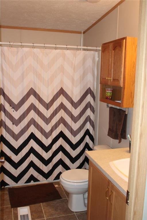 bathroom featuring vanity, a textured ceiling, tile patterned floors, walk in shower, and toilet