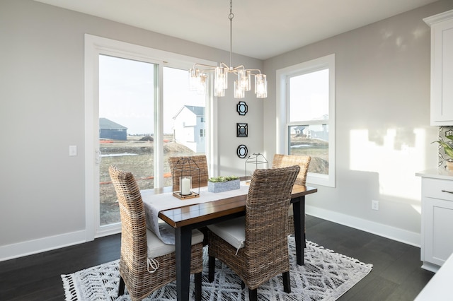 dining space with dark hardwood / wood-style flooring and a notable chandelier