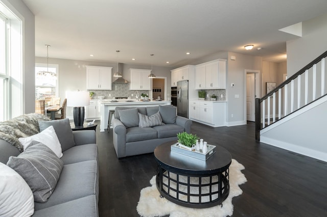 living room featuring plenty of natural light, a chandelier, and dark hardwood / wood-style floors