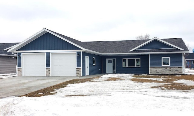 view of front of home with an attached garage, stone siding, and driveway