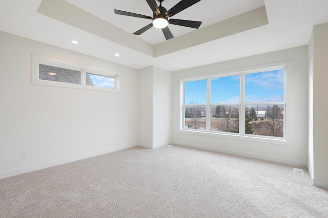 spare room featuring ceiling fan, a raised ceiling, and carpet floors